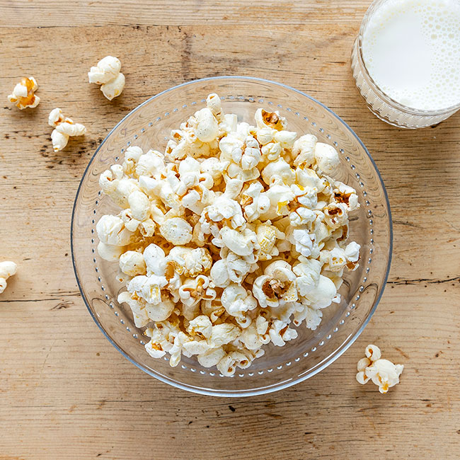 Salta popcorn med ett litet glas kall mjölk